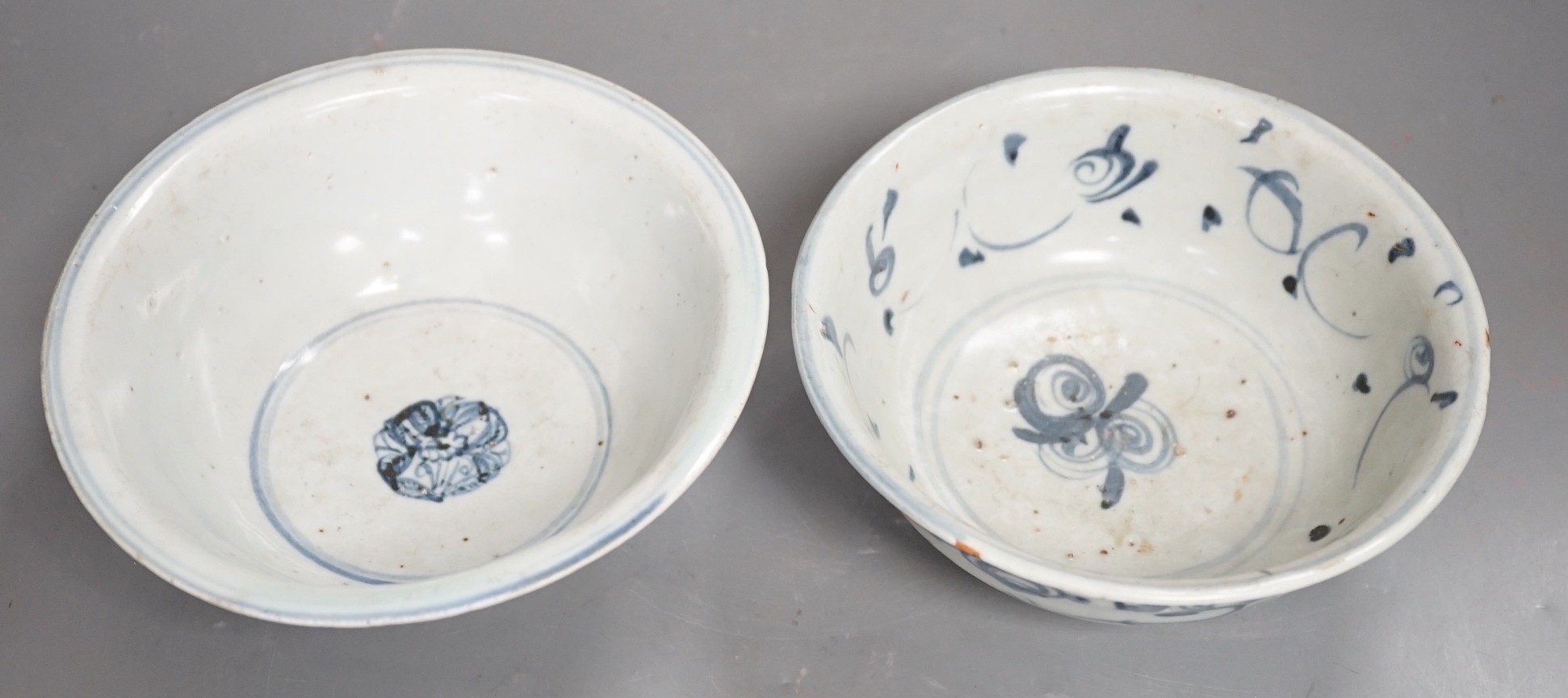 Two Chinese late Ming blue and white bowls, 16th/17th century, painted with flowers and foliage, 14.3 and 15.8cm
